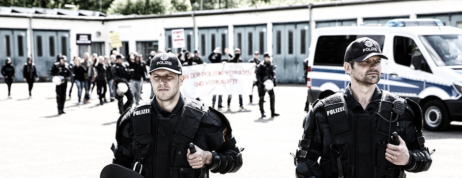 Zwei Polizeibeamte bewachen eine Demonstration.