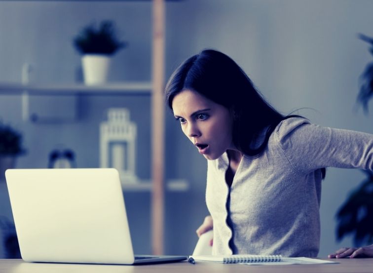 Jugendliche schaut entsetzt auf den Laptop